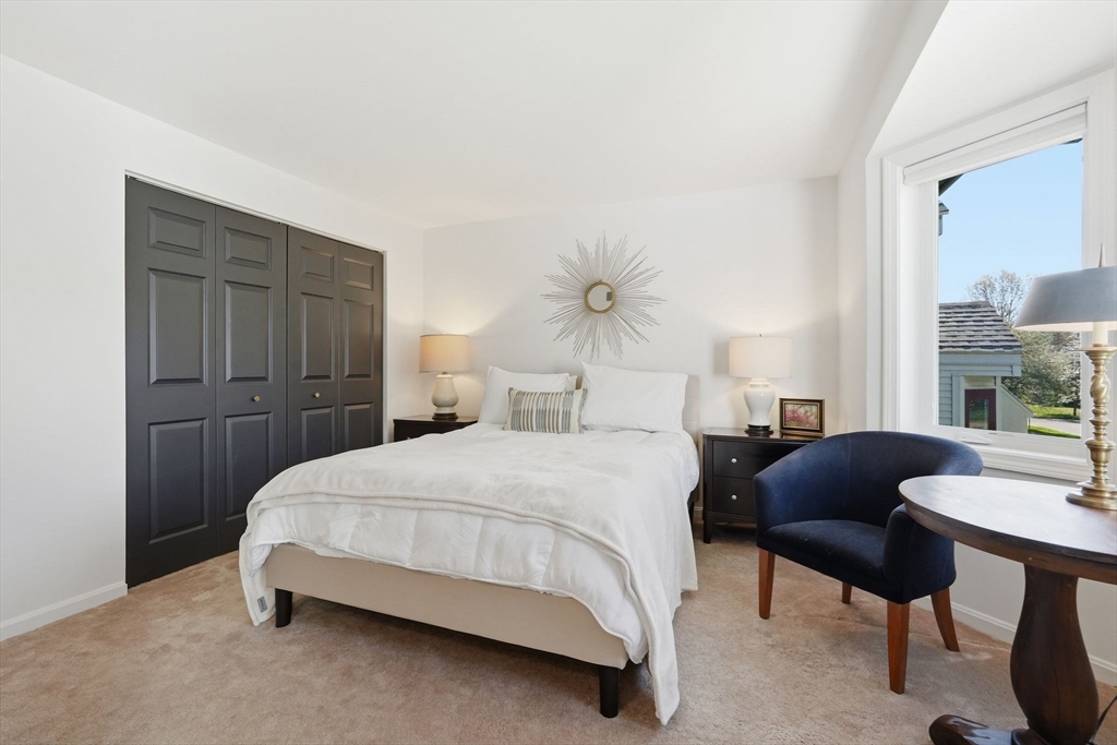 24 McIntosh Drive, Unit 24 Amherst, MA 01002 - Photo 25 of 39 a bedroom with a bed and a chandelier