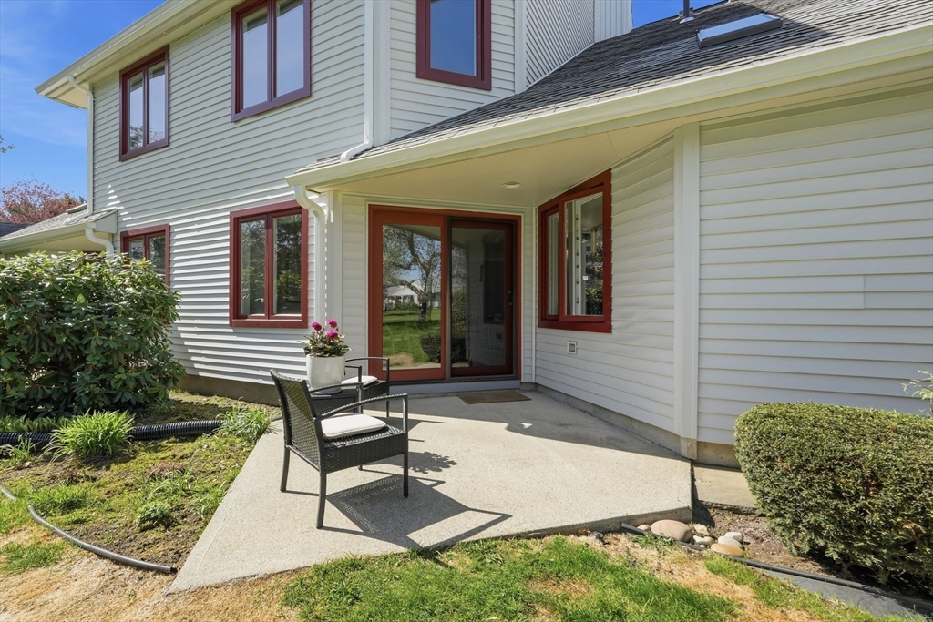 24 McIntosh Drive, Unit 24 Amherst, MA 01002 - Photo 7 of 39 a front view of a house with a chairs and table in a patio