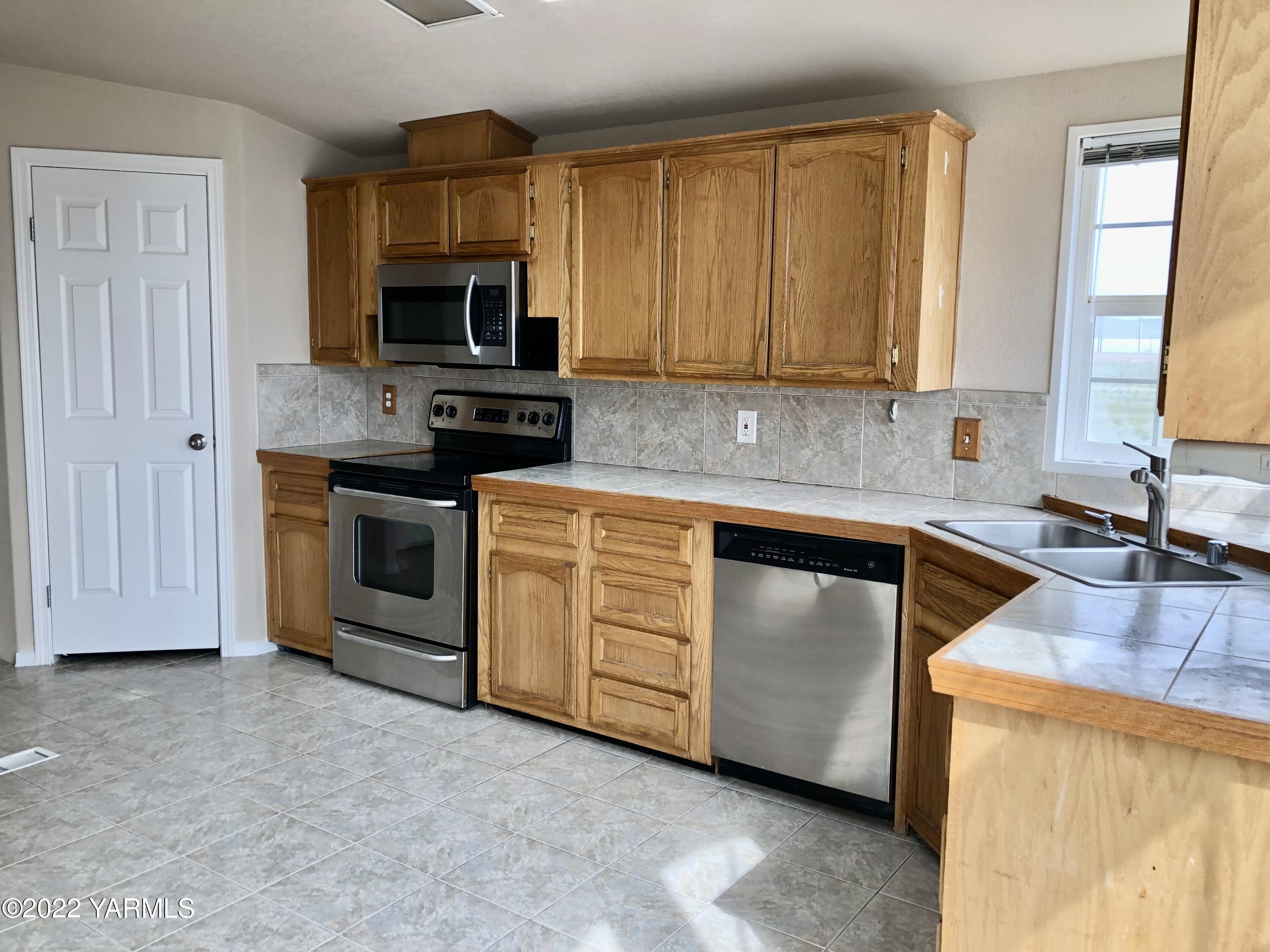 4912 Lateral A Road Wapato, WA 98951 - Photo 11 of 31 a kitchen with a sink stove and microwave
