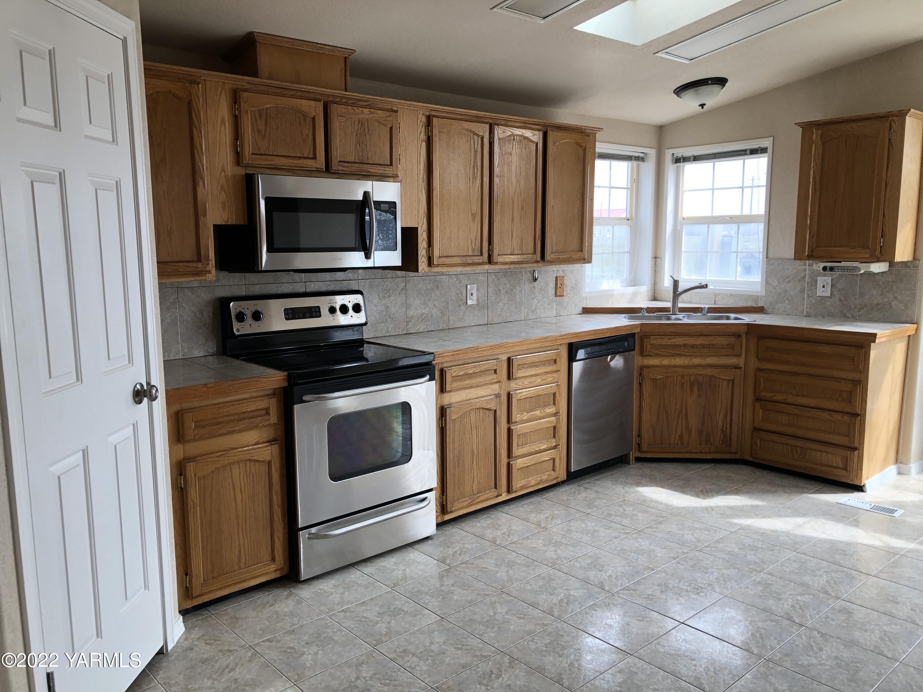 4912 Lateral A Road Wapato, WA 98951 - Photo 12 of 31 a kitchen with stainless steel appliances granite countertop a stove a sink and a microwave