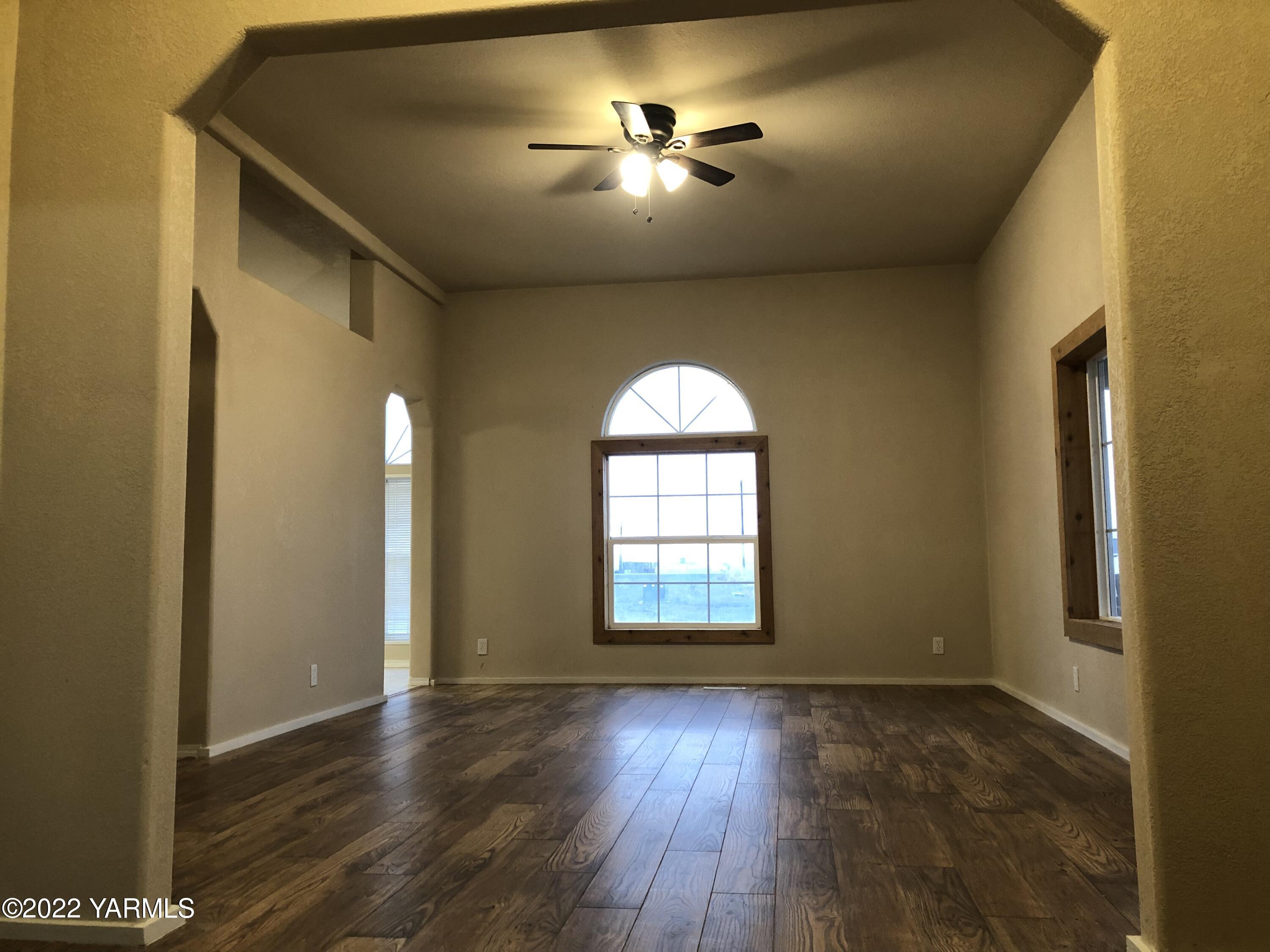 4912 Lateral A Road Wapato, WA 98951 - Photo 8 of 31 an empty room with wooden floor and chandelier fan