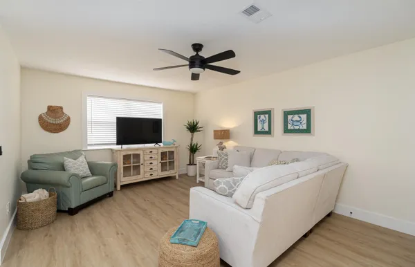 a living room with furniture and a view of kitchen