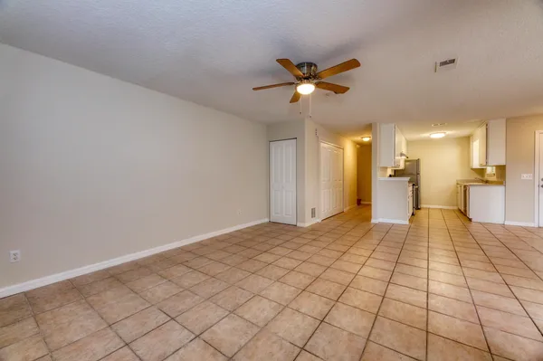 an empty room with a window and a ceiling fan