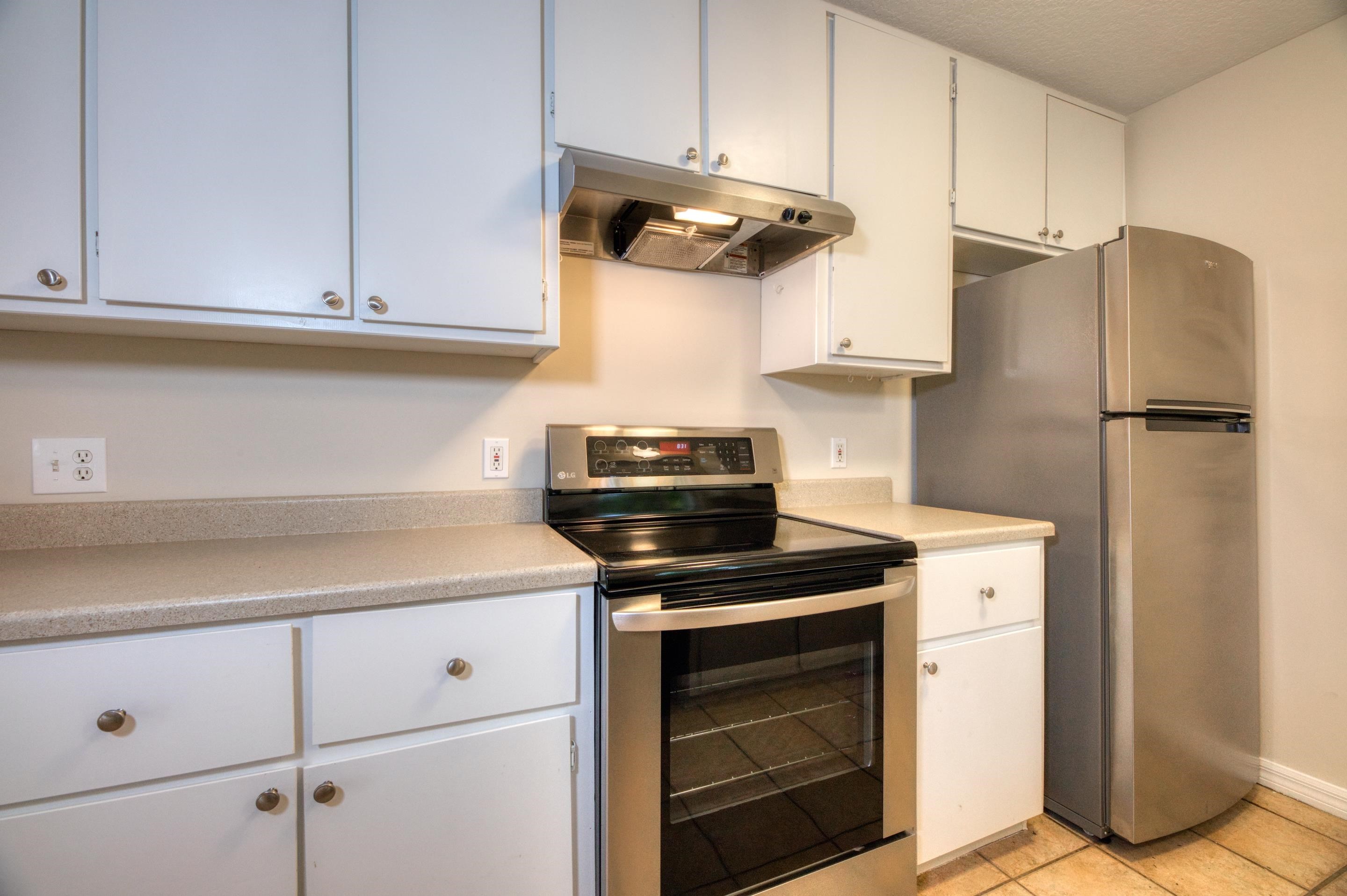 203 E Street St. Augustine, FL 32080 - Photo 37 of 68 Kitchen featuring stainless steel appliances, under cabinet range hood, light countertops, and white cabinetry