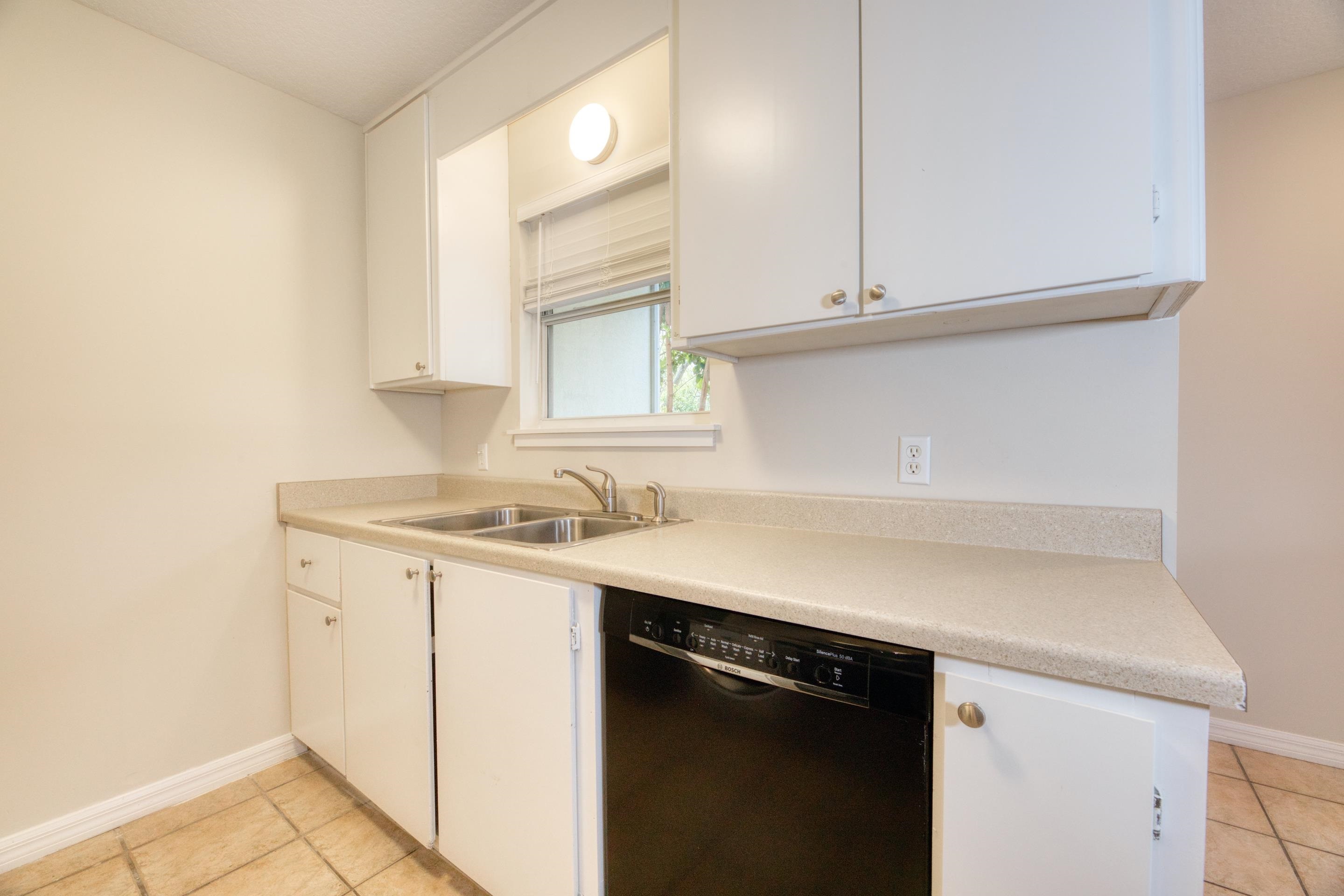 203 E Street St. Augustine, FL 32080 - Photo 38 of 68 Kitchen featuring black dishwasher, light countertops, white cabinetry, and light tile patterned flooring