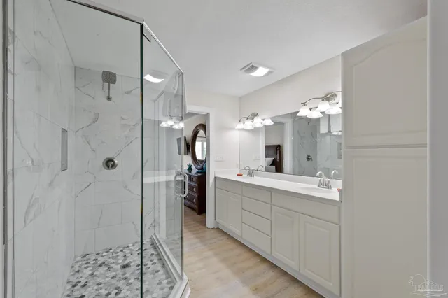 a bathroom with a double vanity sink mirror and shower