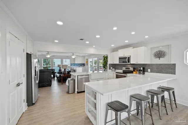 a kitchen with stainless steel appliances kitchen island granite countertop a refrigerator and a stove top oven