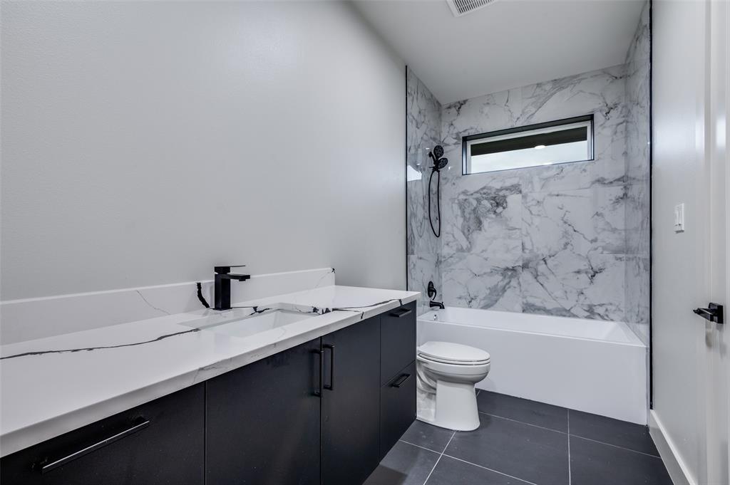 6301 Tiffany Oaks Lane Arlington, TX 76016 - Photo 27 of 40 a bathroom with a granite countertop sink a toilet and shower