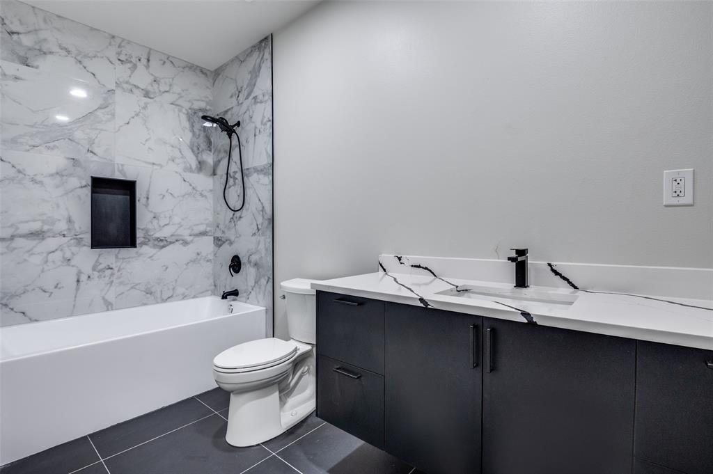 6301 Tiffany Oaks Lane Arlington, TX 76016 - Photo 29 of 40 a bathroom with a granite countertop sink toilet a mirror and shower