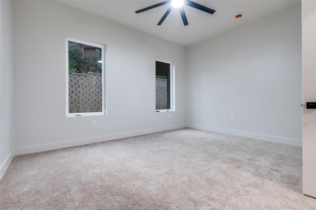 6301 Tiffany Oaks Lane Arlington, TX 76016 - Photo 33 of 40 an empty room with a chandelier fan and windows
