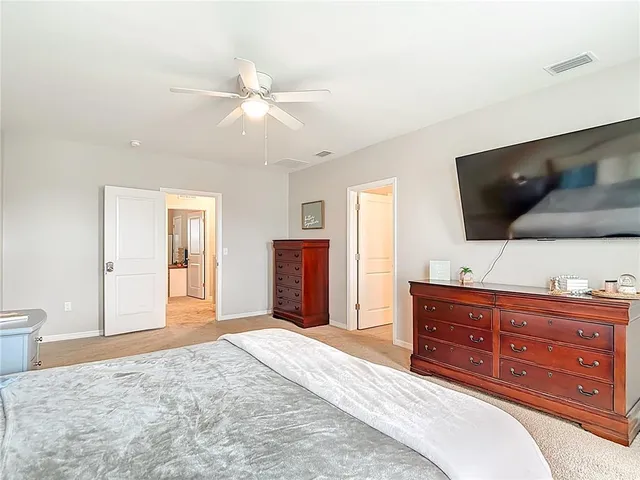 an empty room with a fan & a ceiling fan