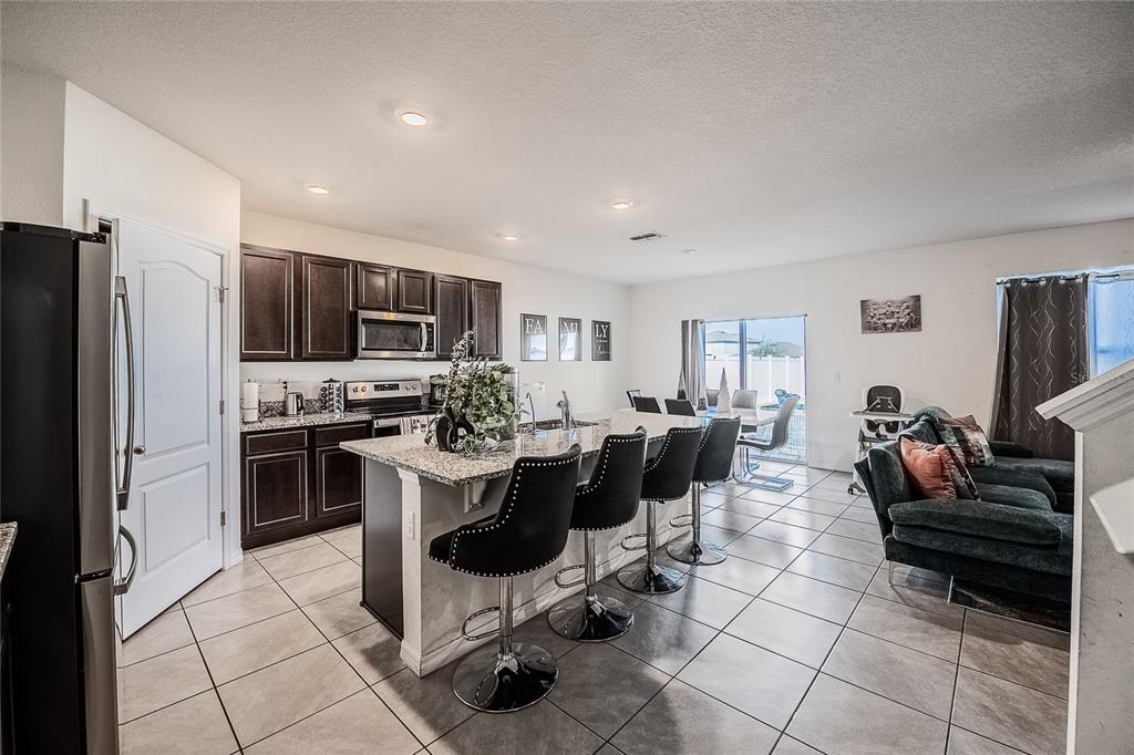 3883 Resting Robin Avenue Bartow, FL 33830 - Photo 6 of 44 a kitchen with a sink stainless steel appliances and cabinets
