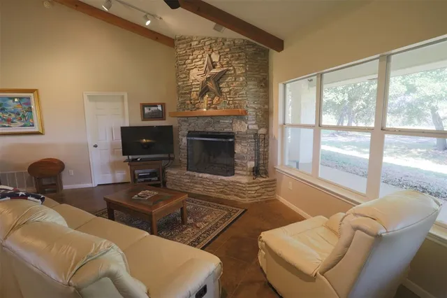 a living room with furniture a fireplace and a flat screen tv