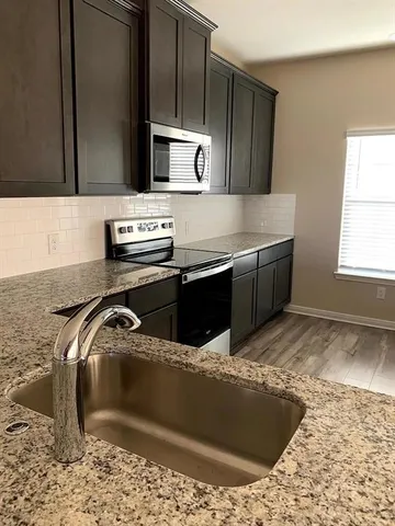 a kitchen with stainless steel appliances granite countertop a sink stove and granite counter tops