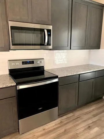 a kitchen with granite countertop cabinets and steel stainless steel appliances