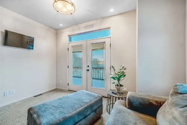 a living room with a bed furniture and a flat screen tv