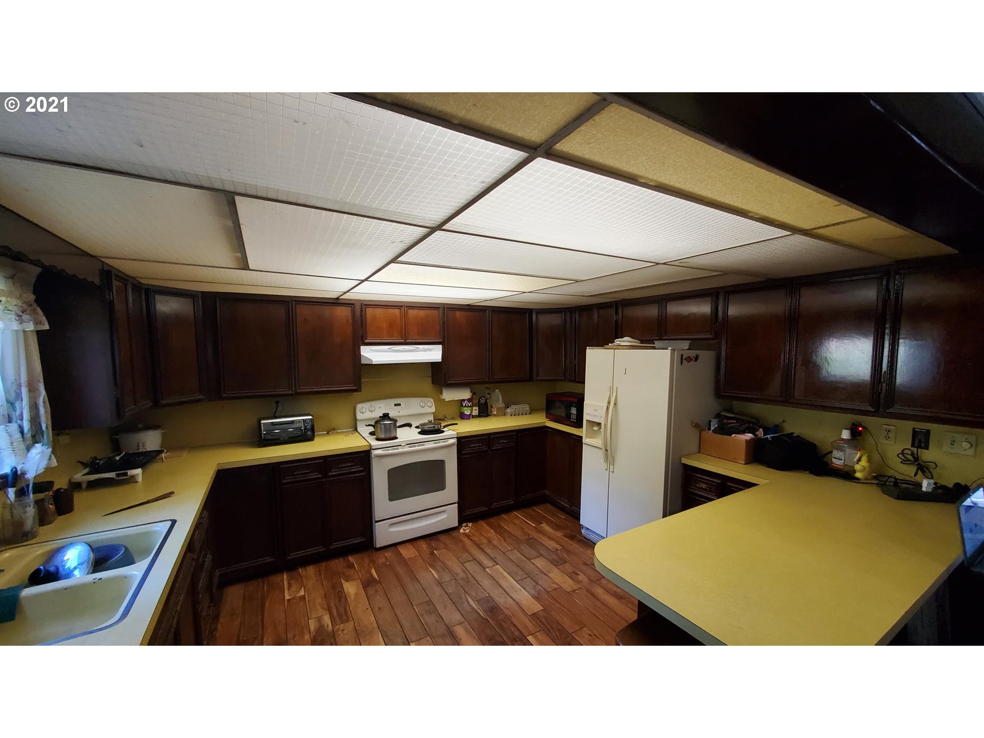 320 West D Street Springfield, OR 97477 - Photo 5 of 19 a kitchen with a refrigerator a stove top oven a sink dishwasher and wooden cabinets
