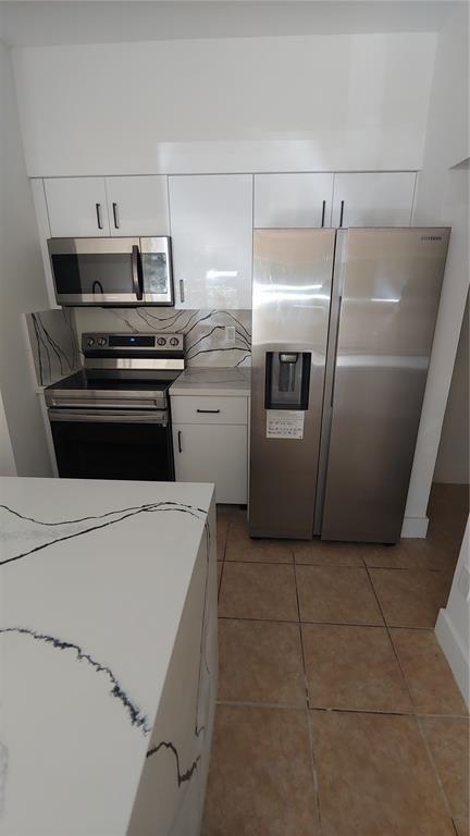 18338 Northwest 68th Avenue, Unit B Hialeah, FL 33015 - Photo 21 of 21 a kitchen with a stove top oven and refrigerator