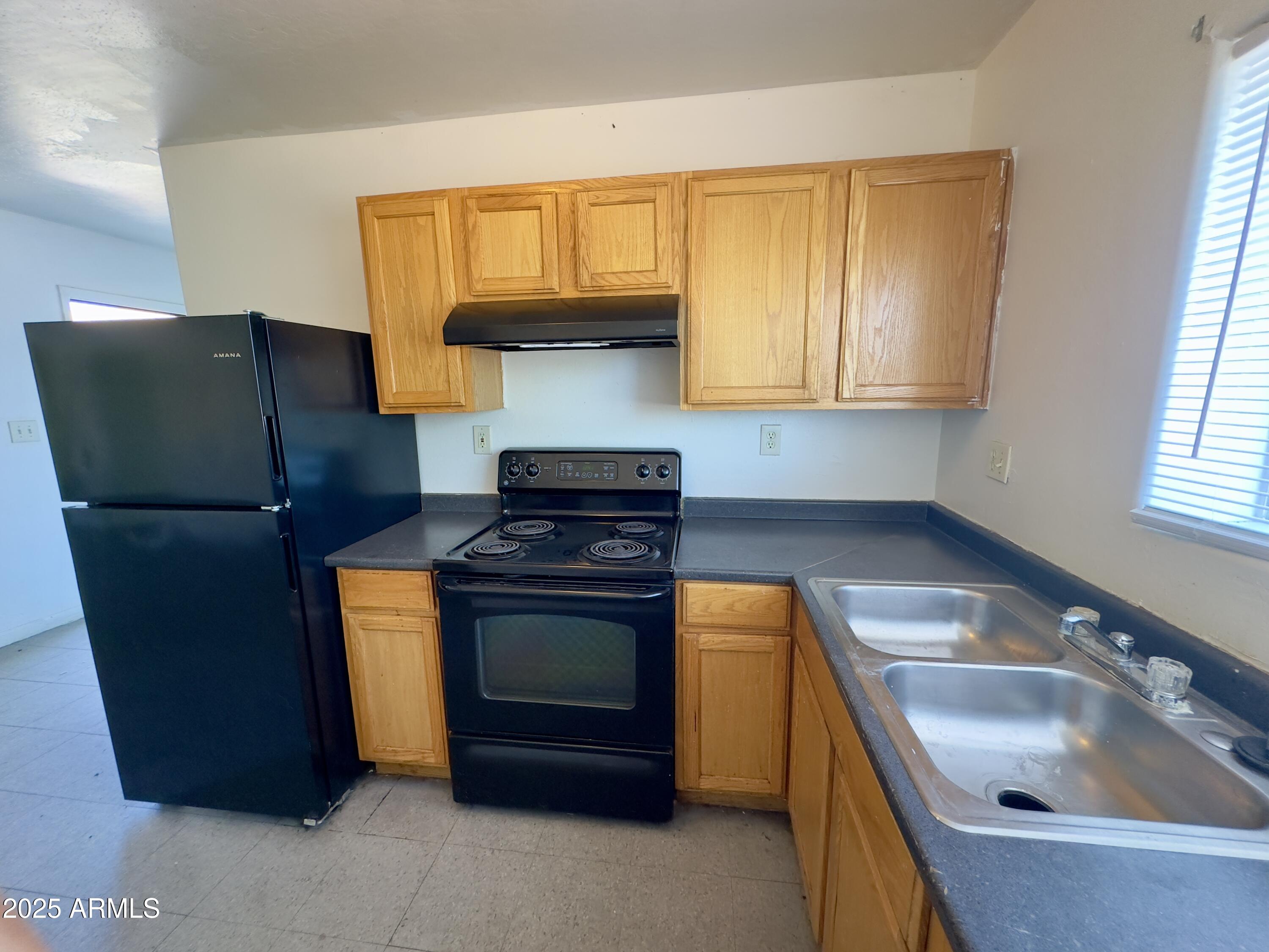 1228 East Apache Street, Unit 2 Phoenix, AZ 85034 - Photo 4 of 15 a kitchen with stainless steel appliances granite countertop a sink stove and refrigerator