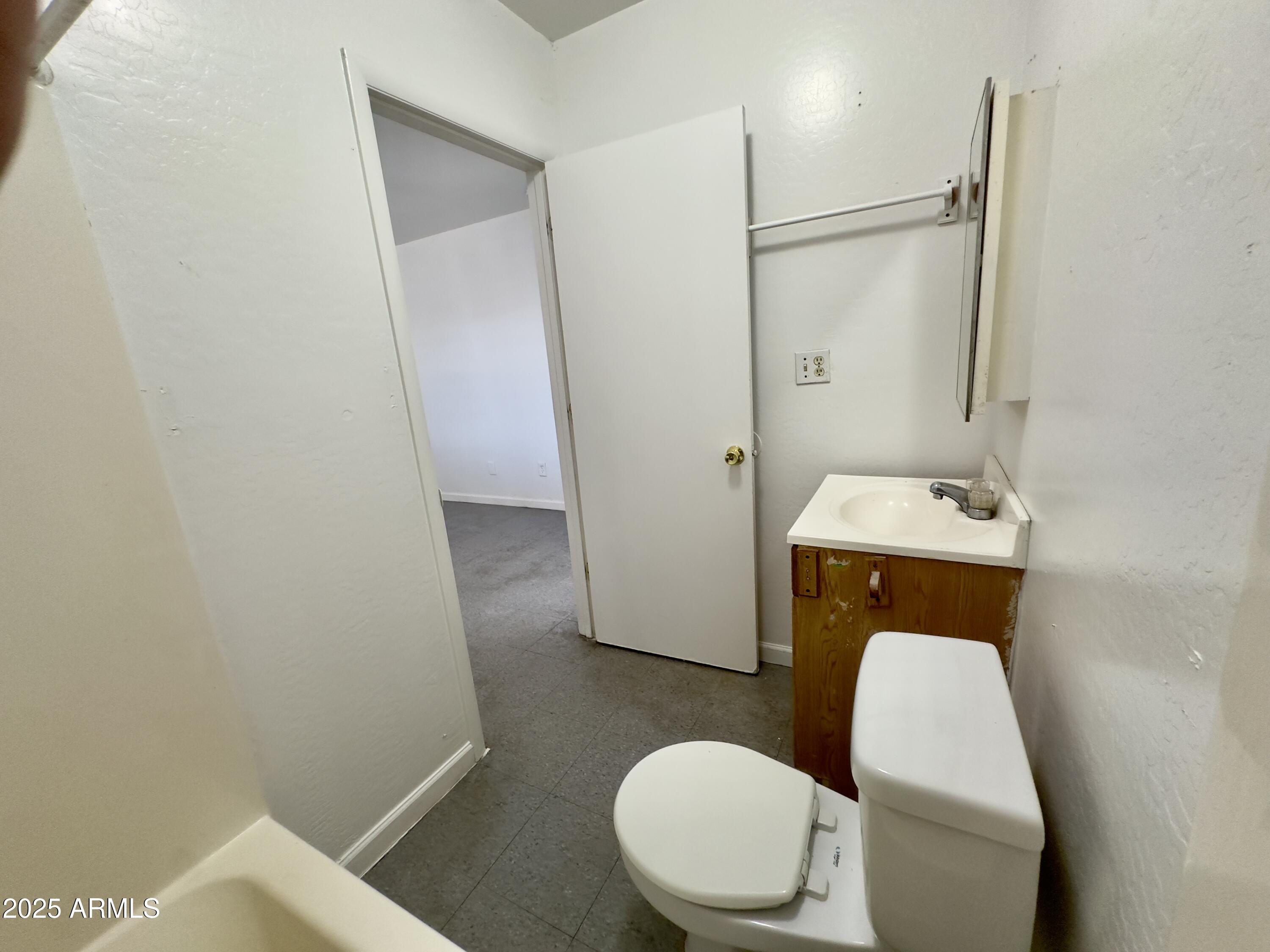 1228 East Apache Street, Unit 2 Phoenix, AZ 85034 - Photo 7 of 15 a white toilet sitting next to a bathroom sink