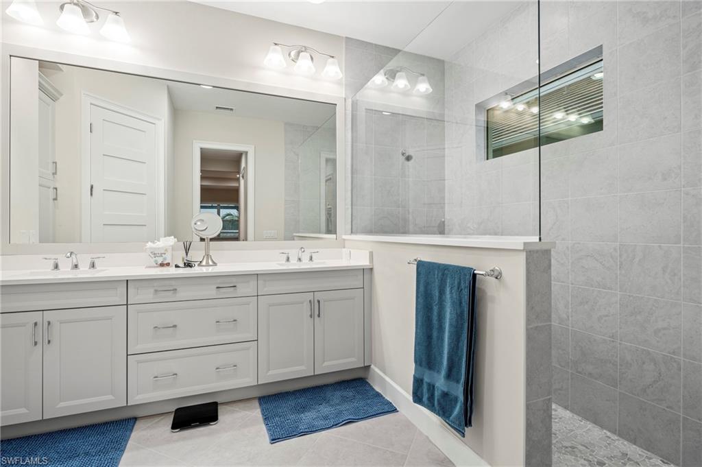 8795 Calypso Court Naples, FL 34113 - Photo 14 of 49 a bathroom with a double vanity sink and a mirror