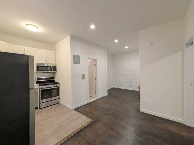 a view of a refrigerator in kitchen and wooden floor
