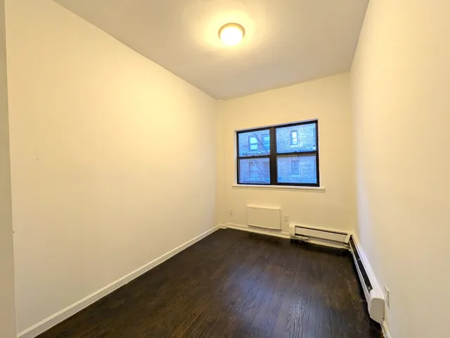 a view of an empty room with a fireplace and a window