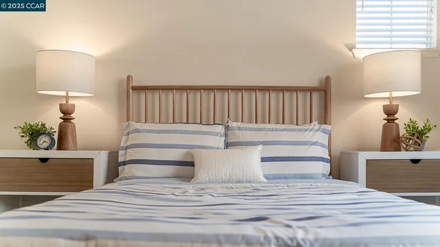 a bedroom with a bed table chair and a window