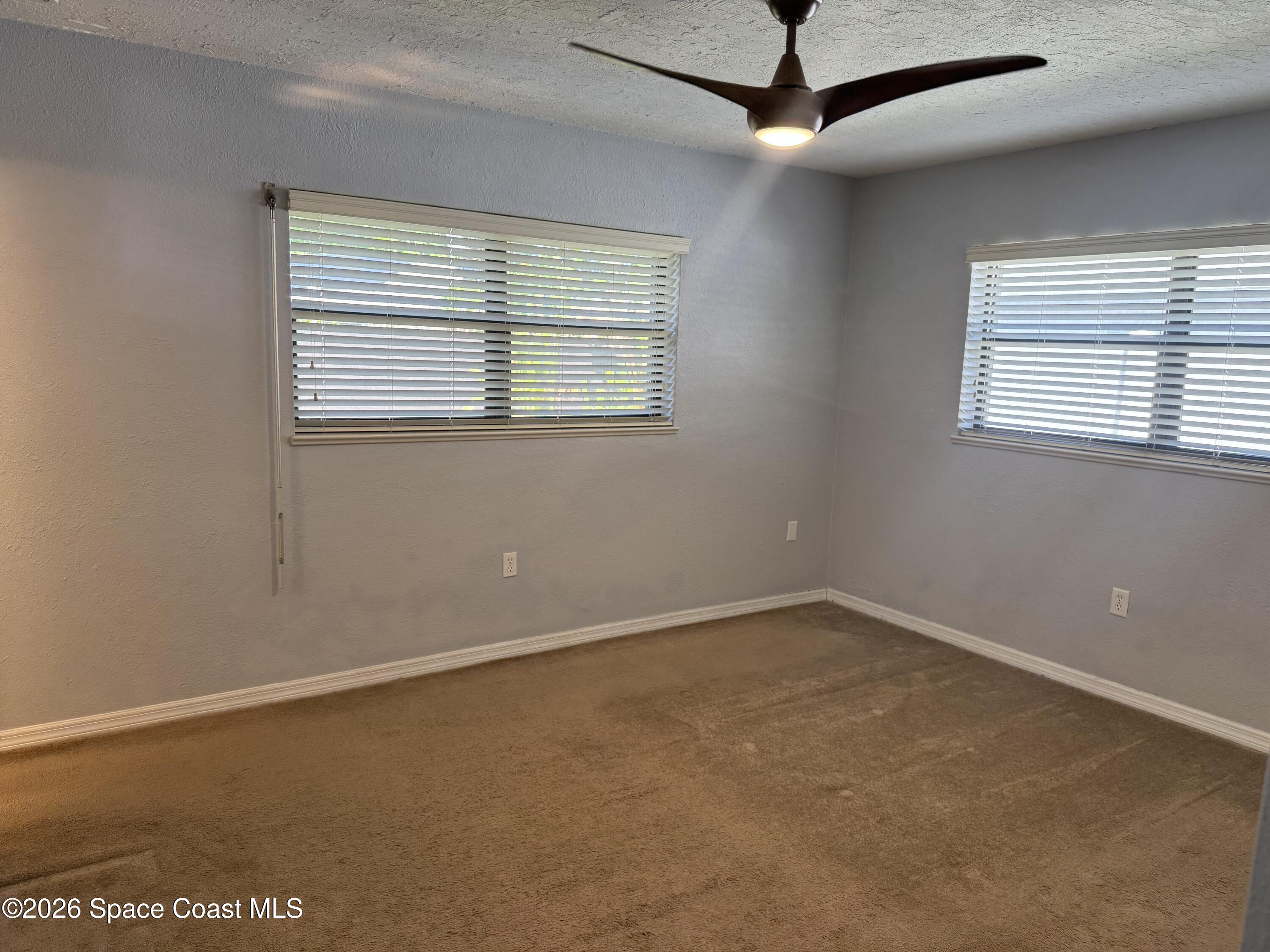 2135 South River Road Melbourne Beach, FL 32951 - Photo 10 of 14 an empty room with a window and a ceiling fan