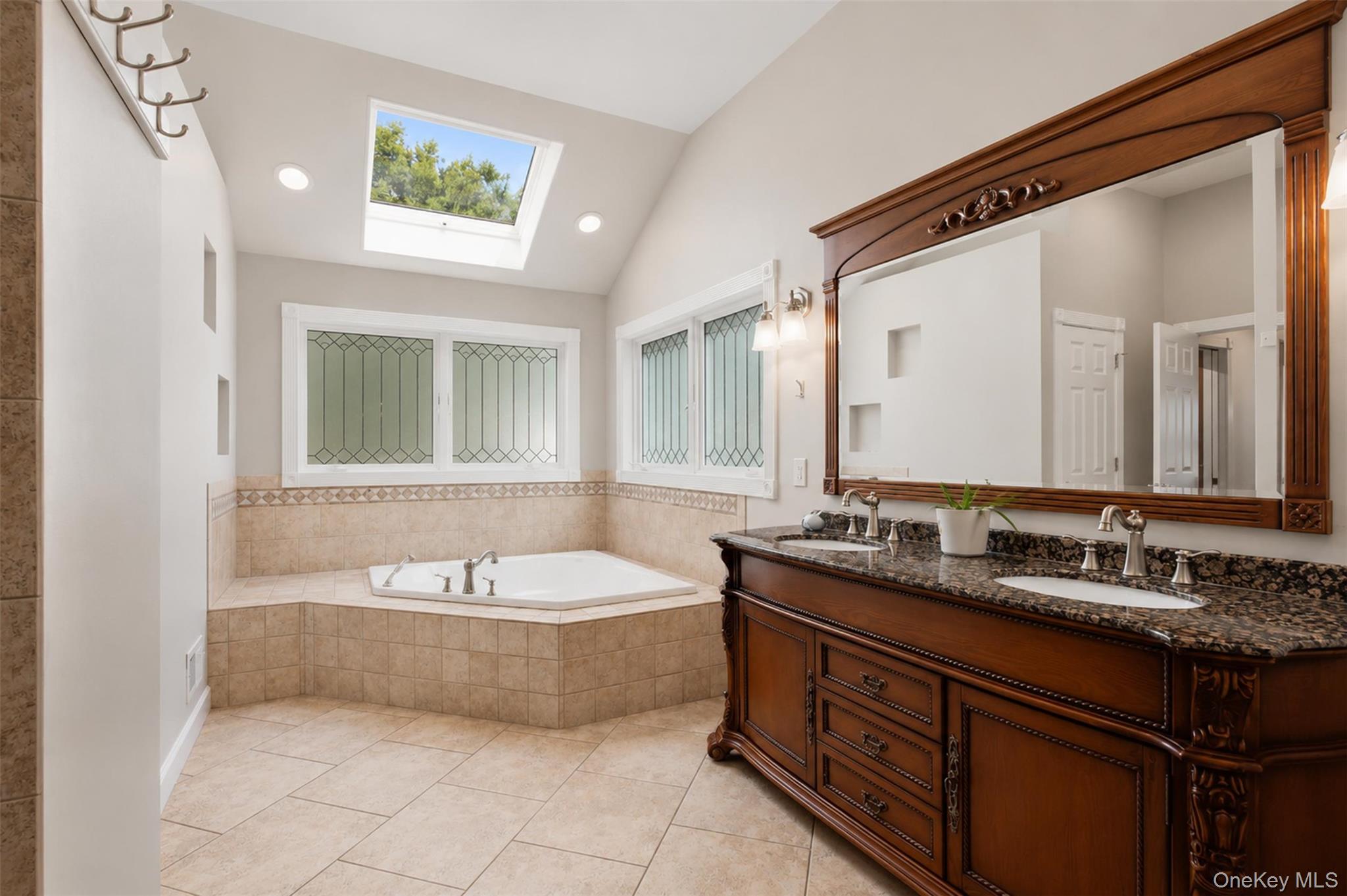 12 Leeside Road Carmel, NY 10512 - Photo 19 of 44 Bathroom featuring a built-in corner jet tub with tiled surround, a large skylight, vaulted ceiling, and recessed lighting