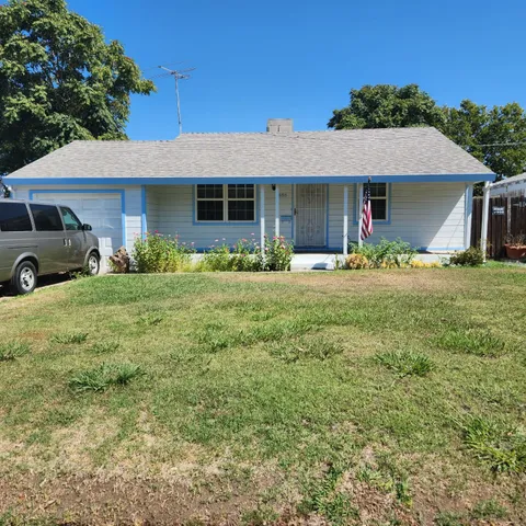 a front view of a house with a yard and trees
