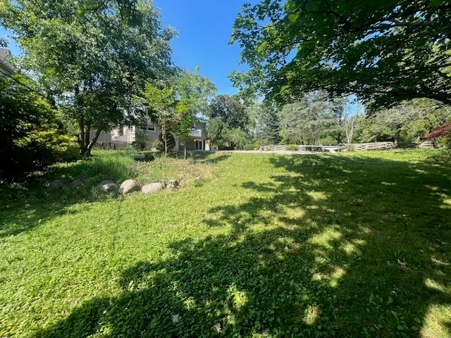 a large yard with lots of green space and trees all around