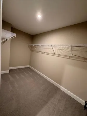 a view of walk in closet with empty racks