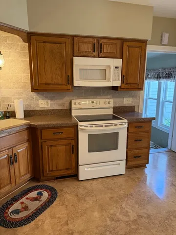 a kitchen with stainless steel appliances granite countertop a stove a sink and a microwave