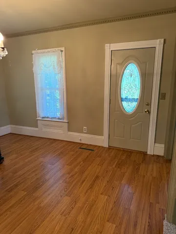 an empty room with wooden floor and a window