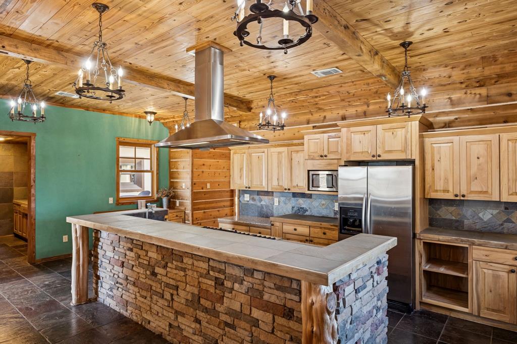 1922 A Bethel-Cannon Road Whitewright, TX 75491 - Photo 9 of 40 Kitchen featuring a stone-faced island with a tiled countertop, wood-finish cabinetry, and stainless steel appliances