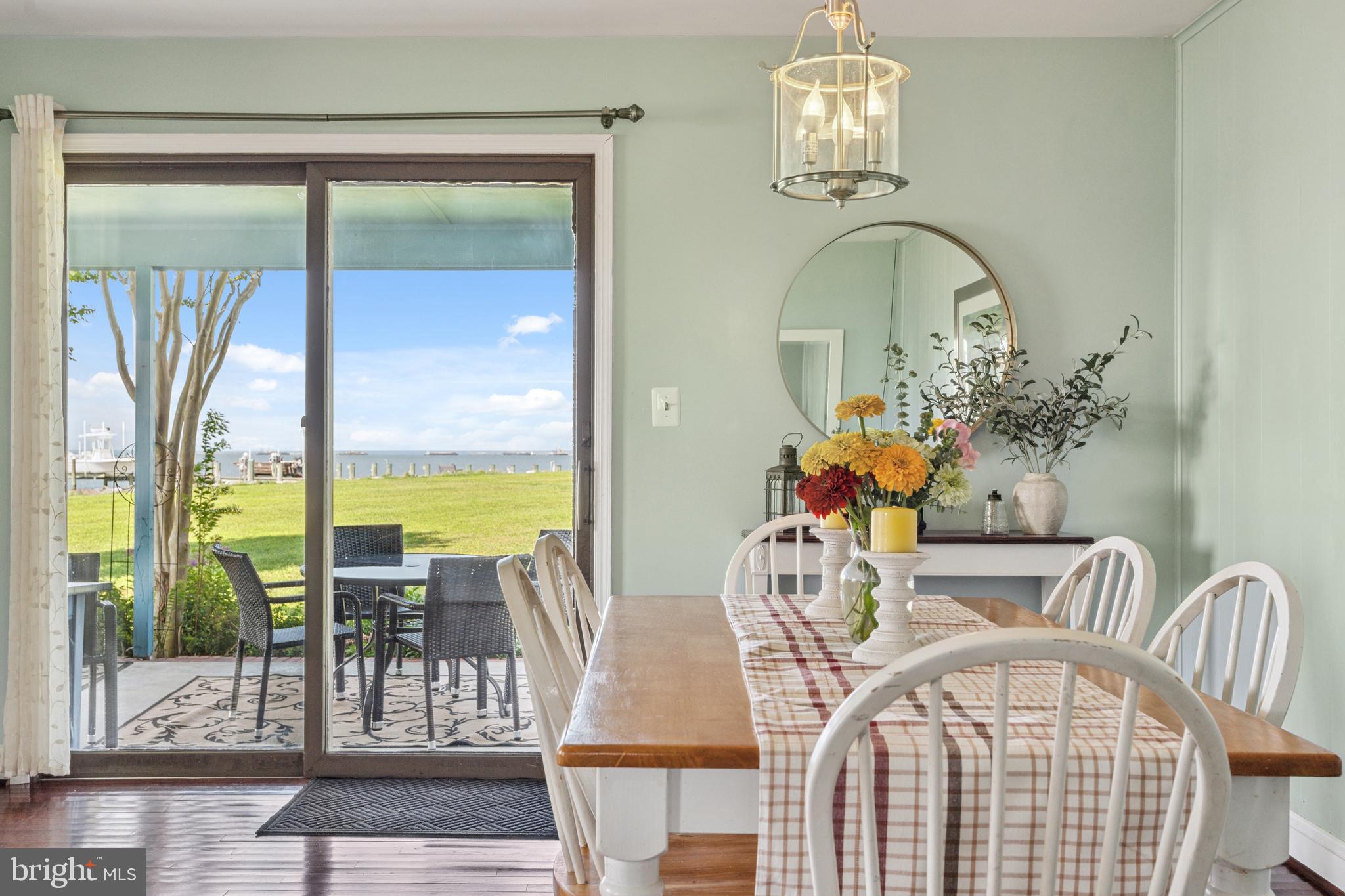 2554 Hoopers Island Road Fishing Creek, MD 21634 - Photo 20 of 85 a view of a dining room with furniture a chandelier and wooden floor