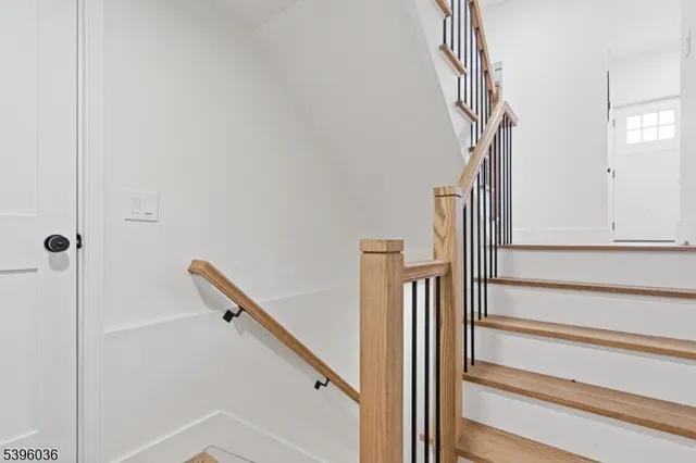 a view of staircase with white walls and railing