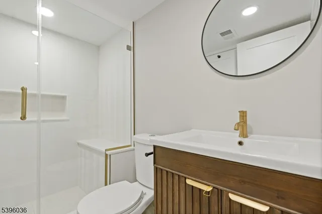 a bathroom with a sink vanity mirror and toilet