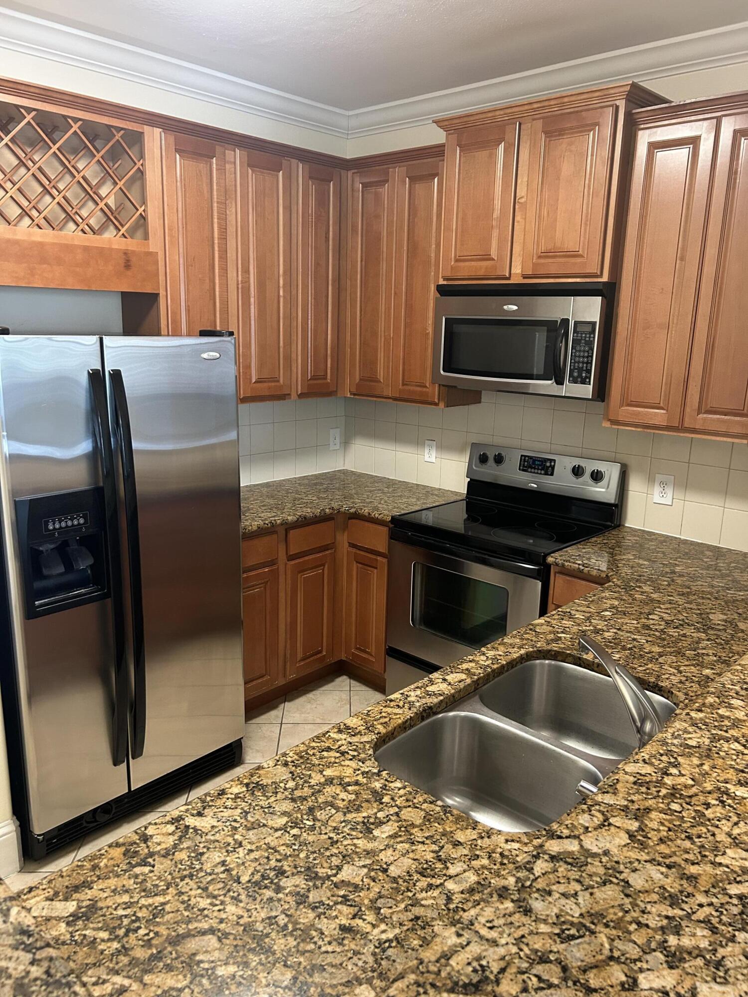 17 Bald Eagle Court, Unit 6G Santa Rosa Beach, FL 32459 - Photo 3 of 12 a kitchen with stainless steel appliances granite countertop a sink a stove and a refrigerator with wooden cabinets