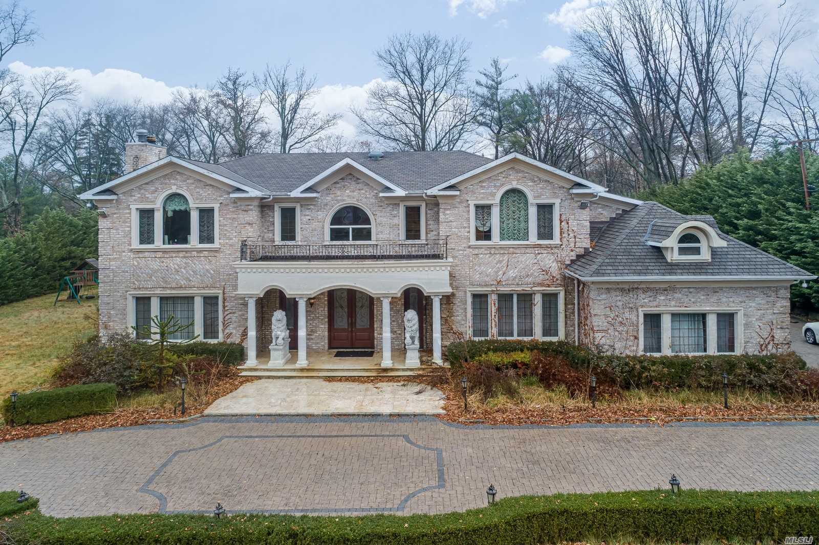 a front view of a house with a yard and trees