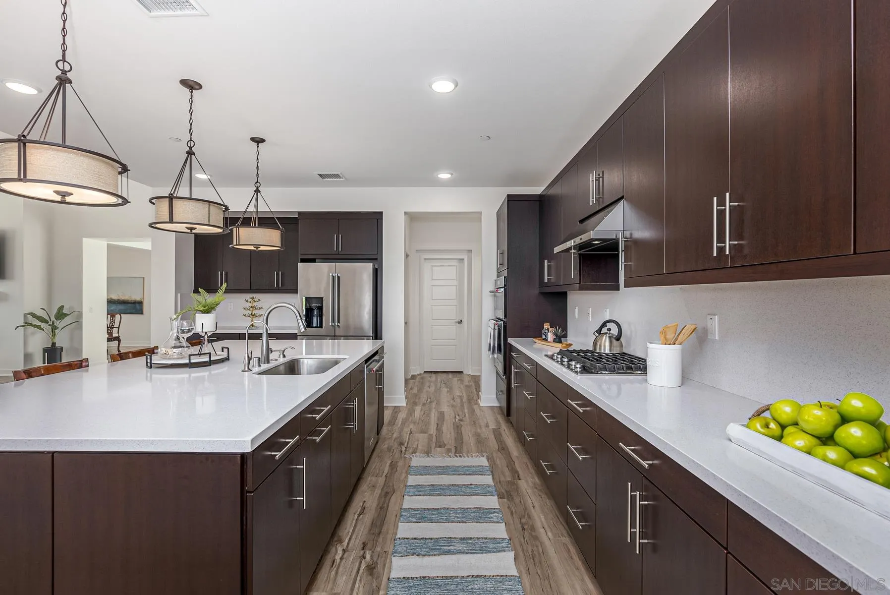 8855 Weston Road Santee, CA 92071 - Photo 14 of 36 a kitchen with kitchen island granite countertop a sink a counter space appliances and cabinets
