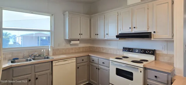 a kitchen with granite countertop white cabinets and white appliances