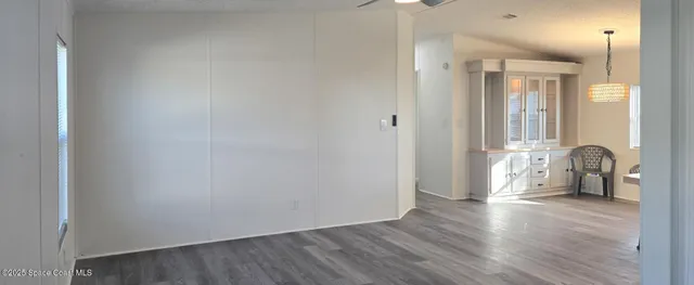 a view of a hallway with wooden floor and furniture