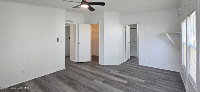 a view of empty room with wooden floor and window