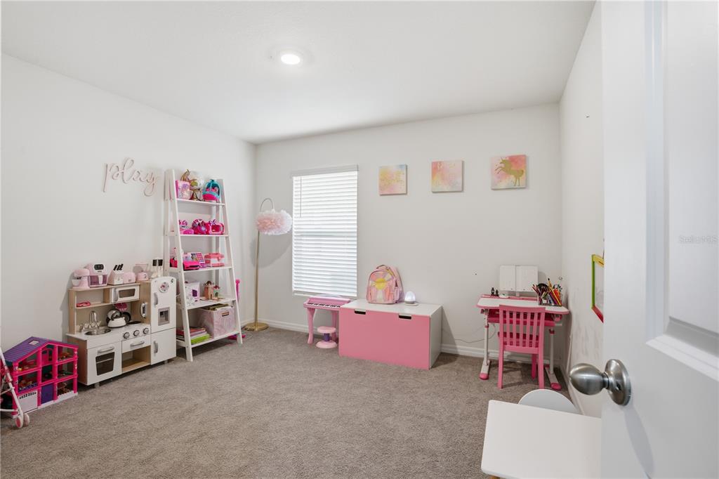 6761 Southeast 3rd Loop Ocala, FL 34472 - Photo 11 of 32 a room with a baby crib and a couch