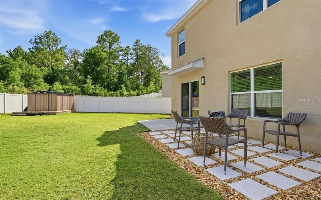 6761 Southeast 3rd Loop Ocala, FL 34472 - Photo 23 of 32 a view of a patio with table and chairs and potted plants with wooden fence