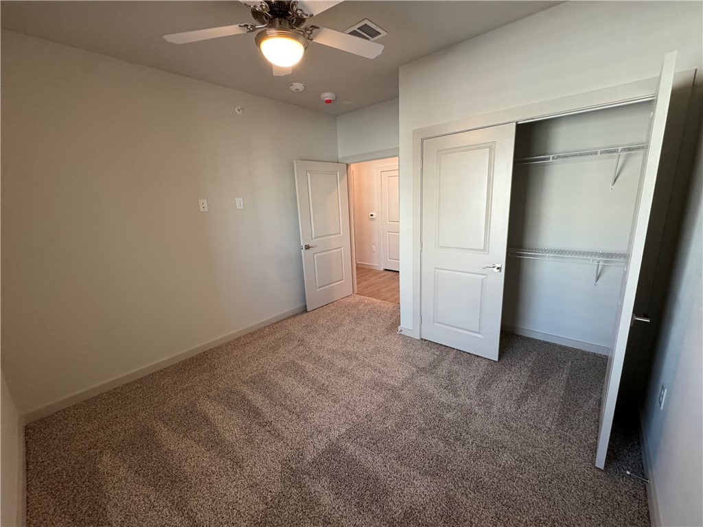 6000 Jones Road, Unit 4207 Bryan, TX 77807 - Photo 16 of 20 an empty room with closet and a chandelier fan