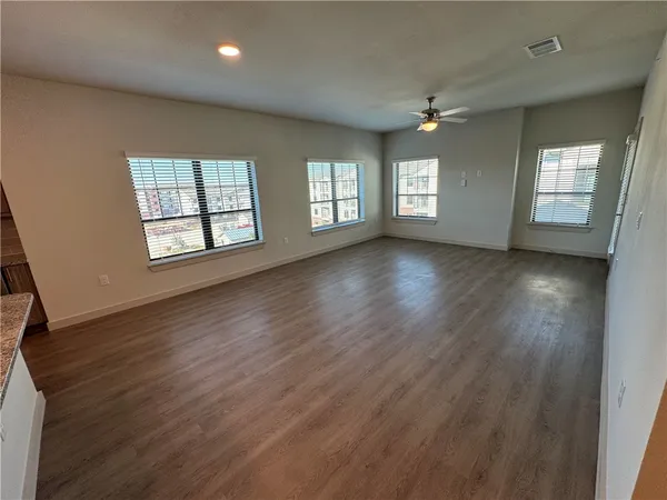 an empty room with closet and a ceiling fan