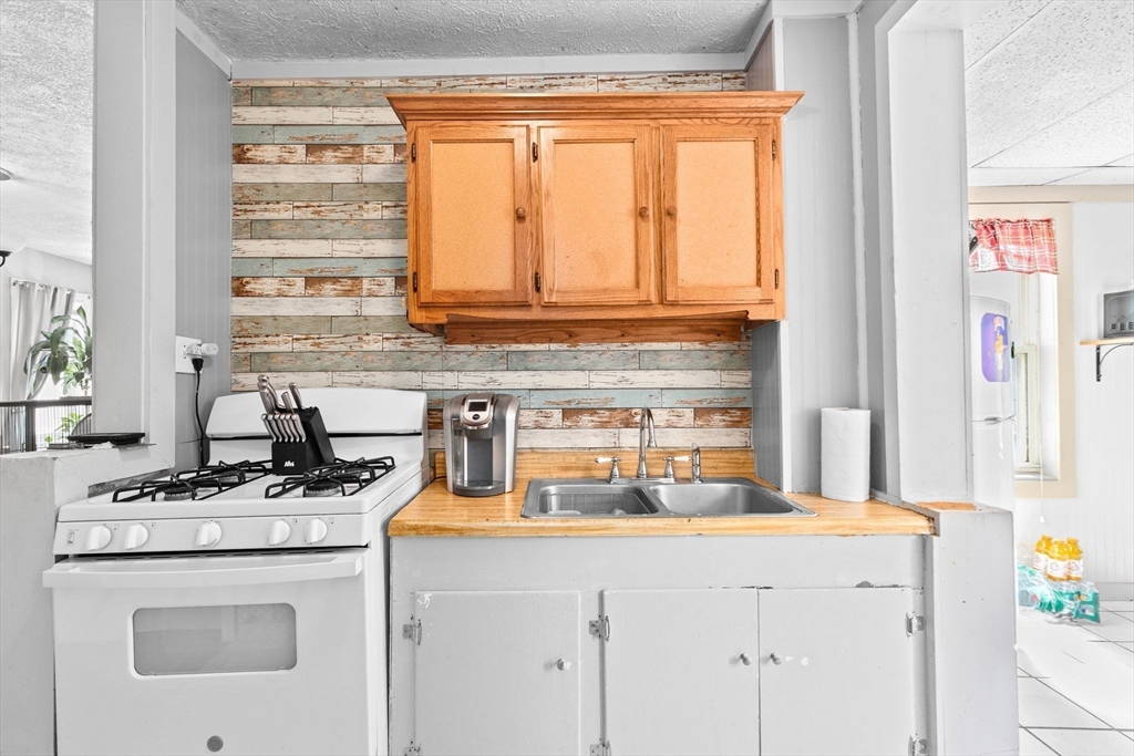 93 Warren Street Fall River, MA 02721 - Photo 18 of 42 a kitchen with a stove and a white cabinets